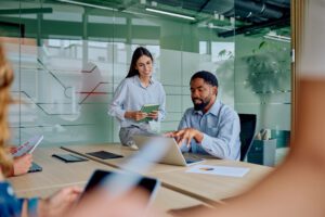 Business professionals discussing their contingent workforce program maturity stage and sharing ideas in a modern glass office.
