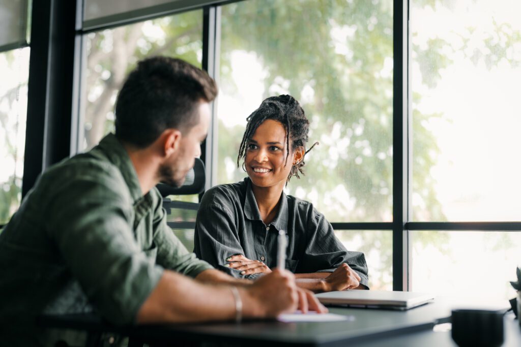 Two people discussing employer of record services in a bright office